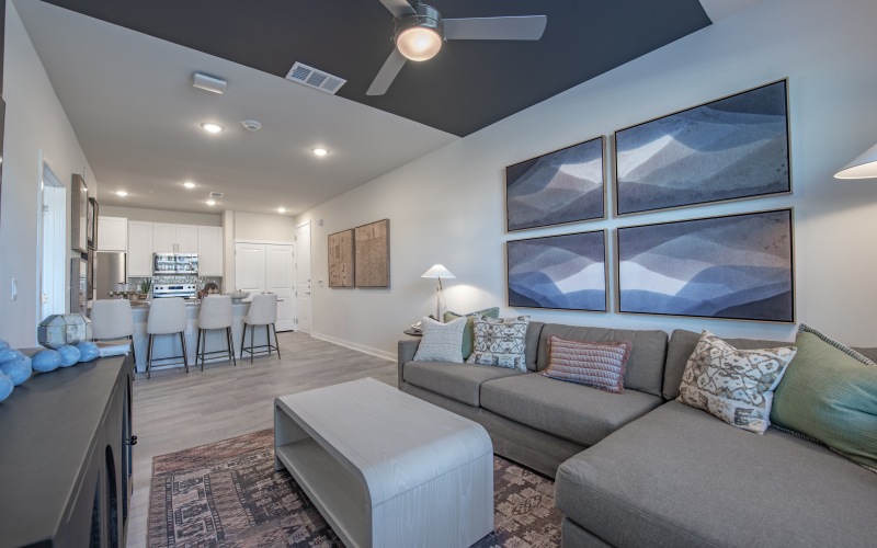 living area with table, couch, kitchen island and stools