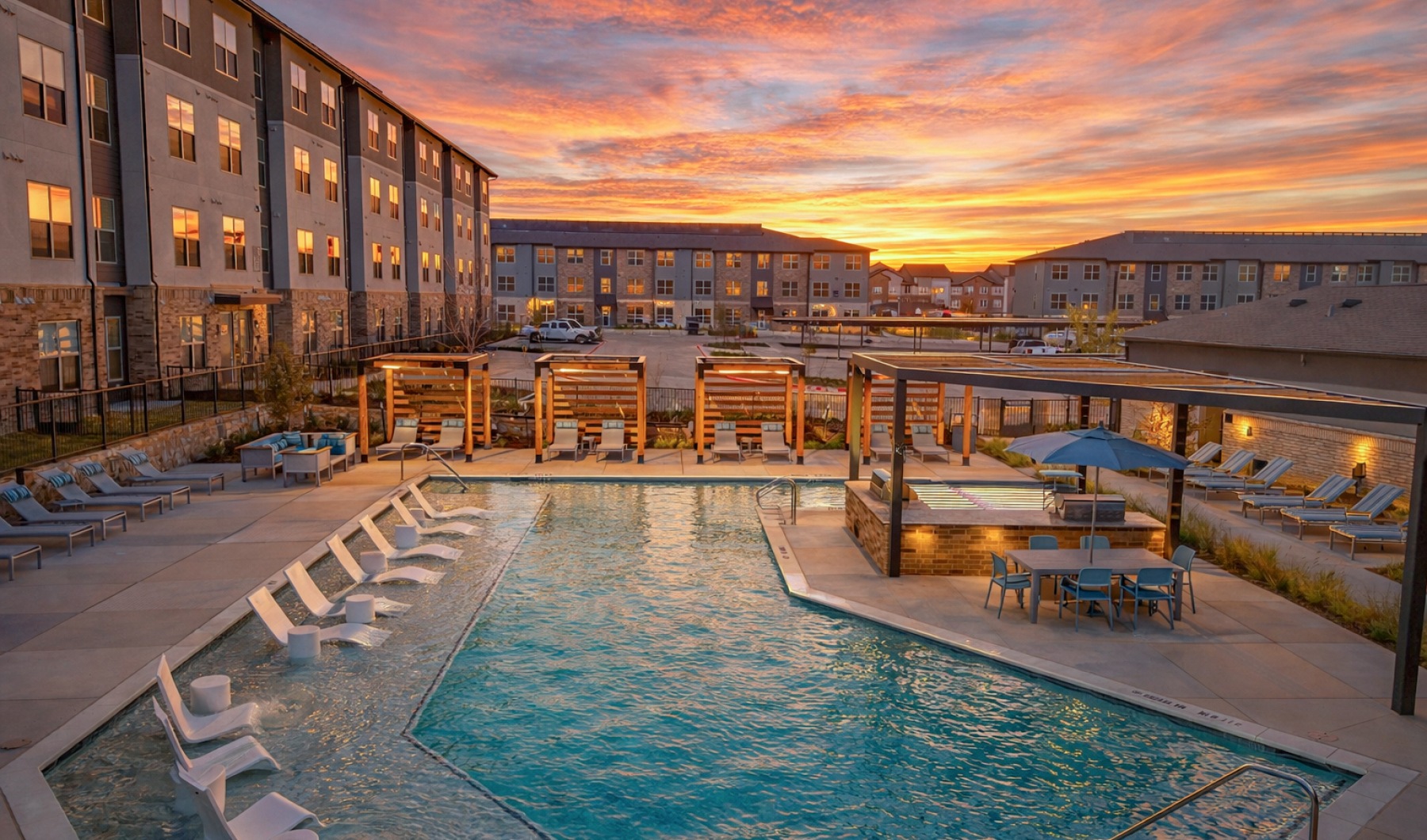 pool with cabanas, grilling, in-water loungers and sunset