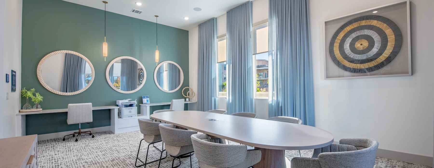 long meeting table with chairs, work stations and printer