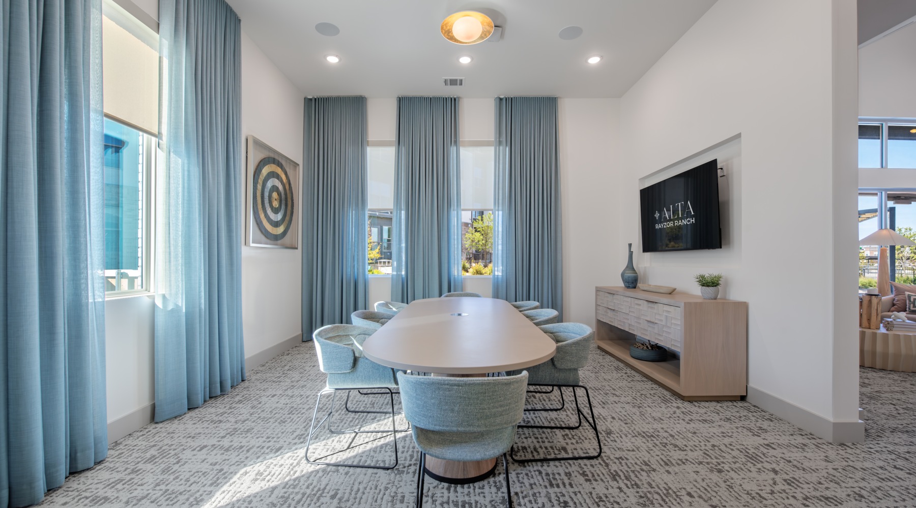 long table with tv, table and large windows