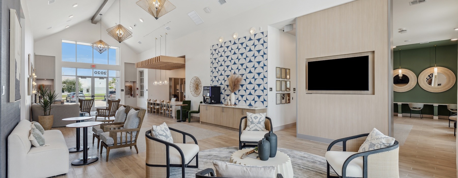 a clubhouse room with chairs, a couch, tables and a tv