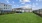a large green lawn with buildings in the background